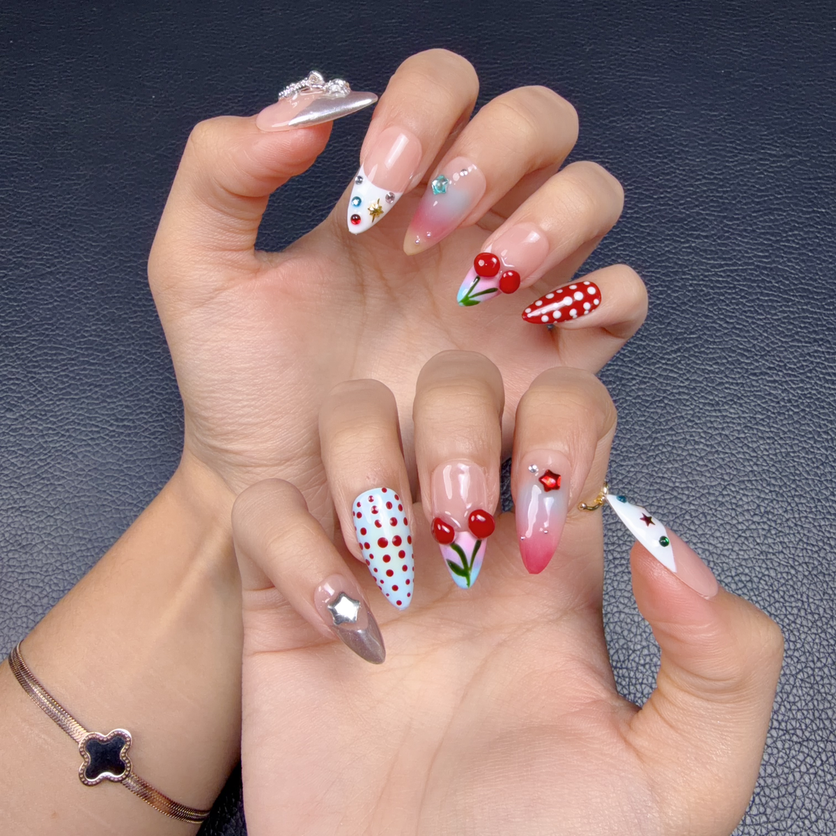 Hands wearing Cherry Rodeo red cherry and blush pink medium almond press-on nails