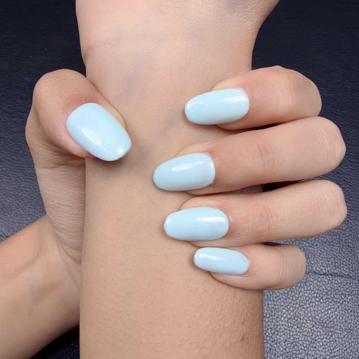 Hands wearing Soft light blue glossy solid color press-on nails