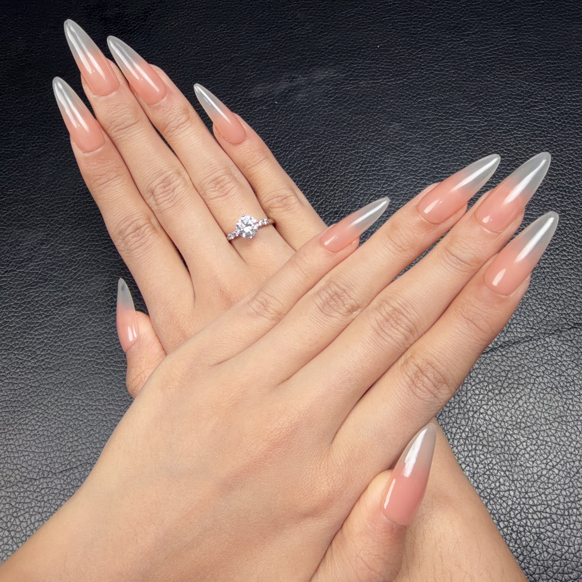 Hands wearing Nude Veil peach nude to grey ombre glossy extra-long oval press-on nails