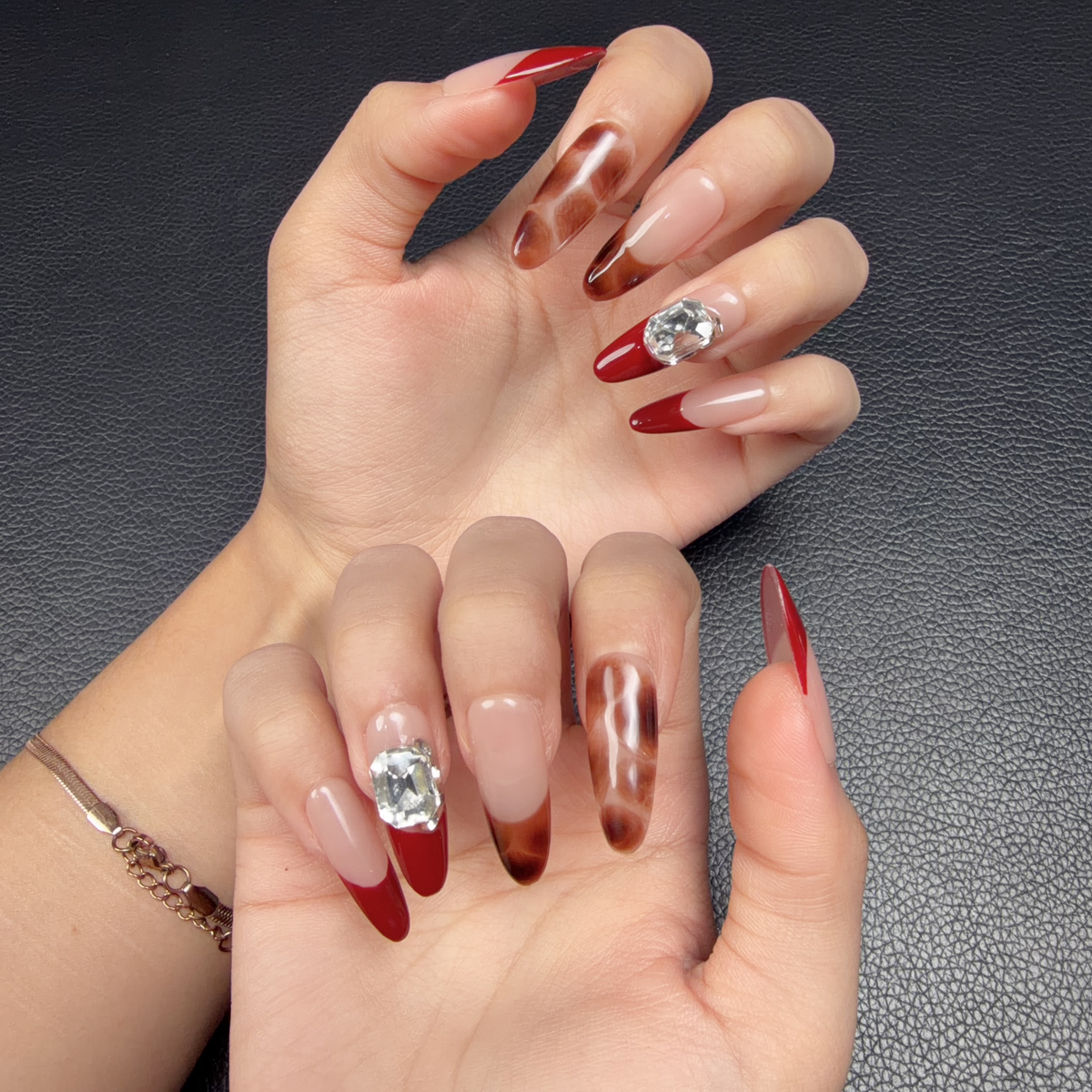 Hands wearing Wine Tortoise burgundy tortoiseshell French tip extra-long oval press-on nails