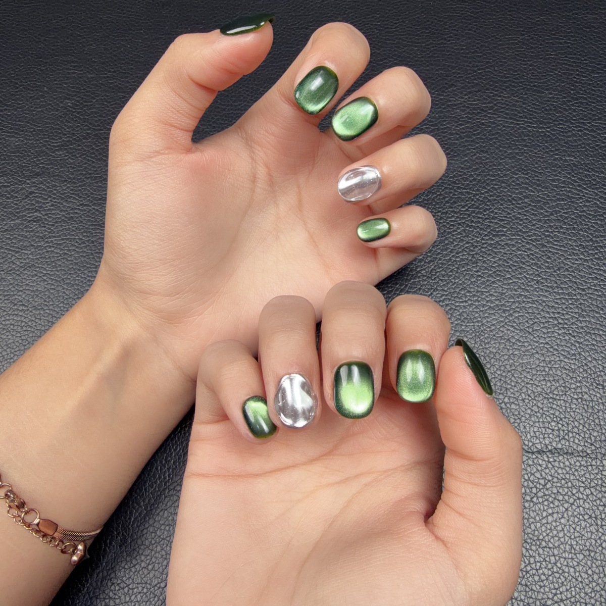 Hands wearing Emerald Mirror green cat eye and silver chrome short squoval press-on nails