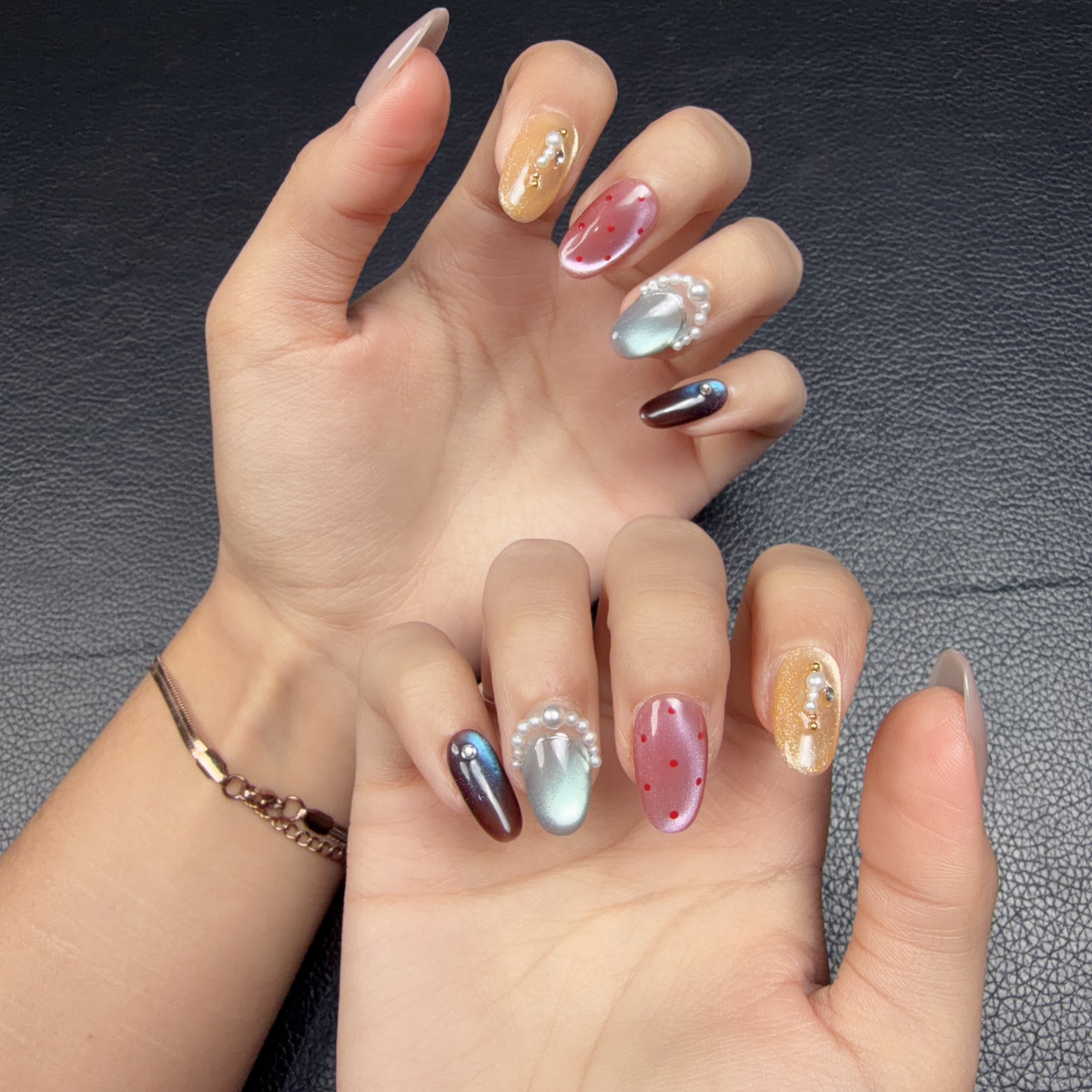 Hands wearing Prism Mood multicolor cat eye pearl short oval press-on nails