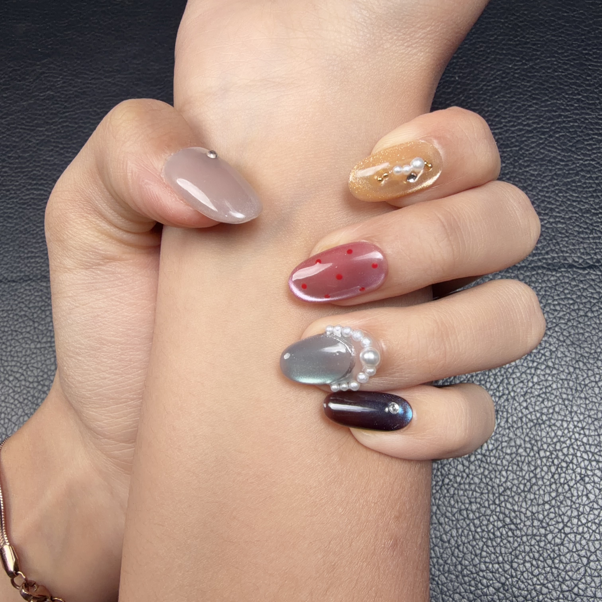 Hands wearing Prism Mood multicolor cat eye pearl short oval press-on nails