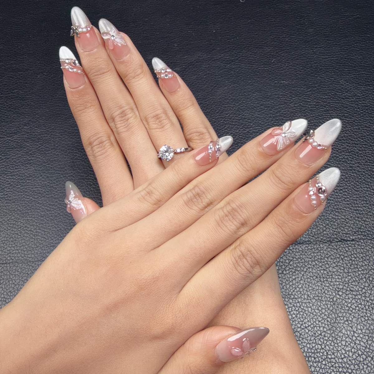 Hands wearing Sheer blush 3D butterfly silver almond press-on nails