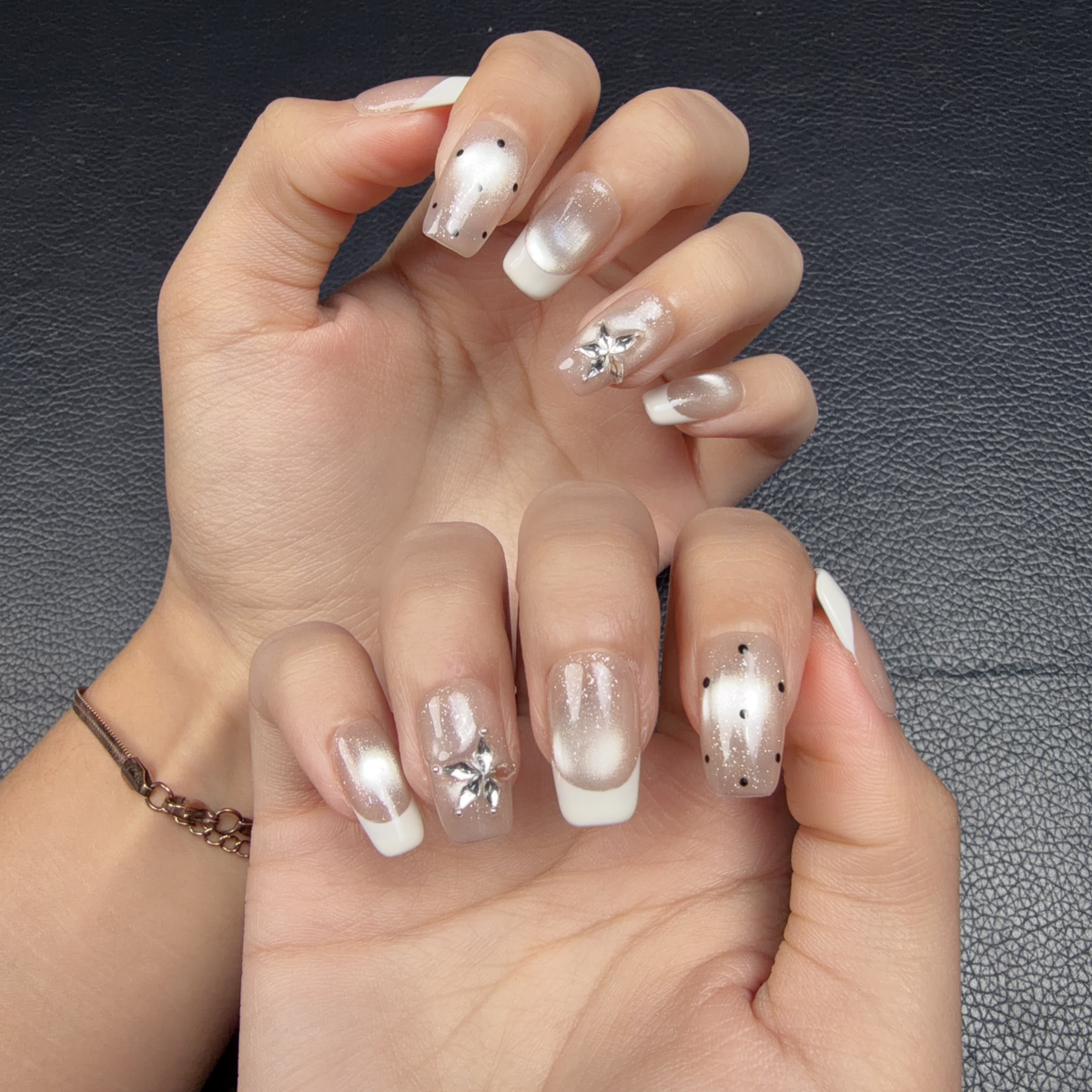 Hands wearing Pearl white French tip silver cat eye square press-on nails with floral accents