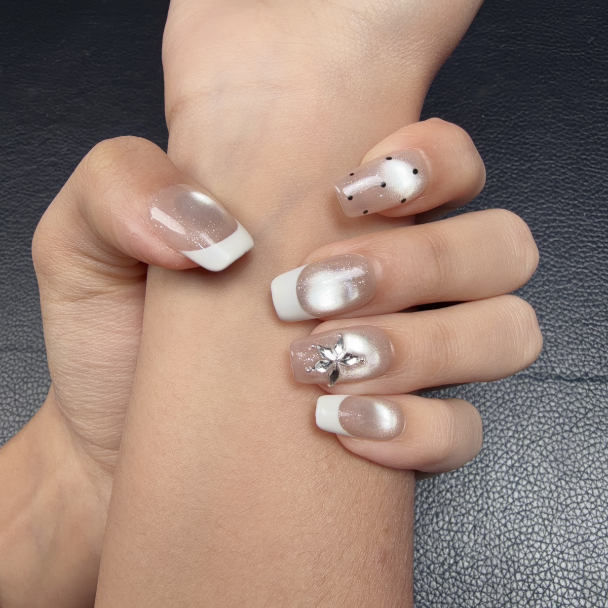 Hands wearing Pearl white French tip silver cat eye square press-on nails with floral accents