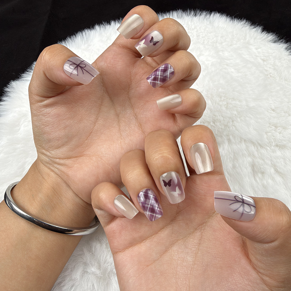 Hands wearing Ribbon Plaid pearl white and plum bow and plaid square press-on nails