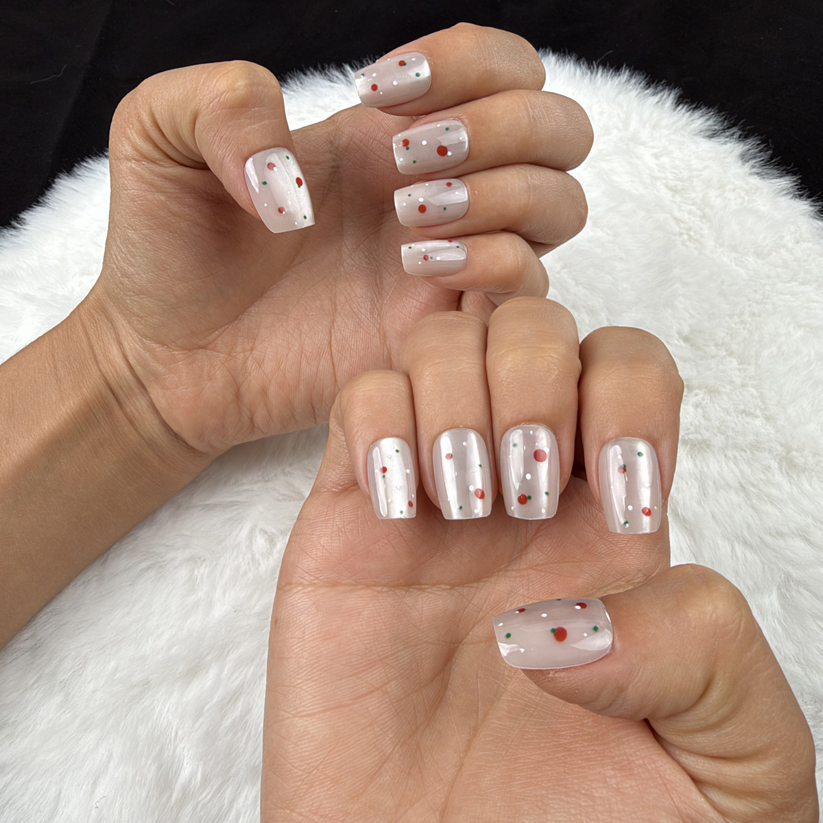 Hands wearing Cherry Pearl pearl white square press-on nails with red cherry accents