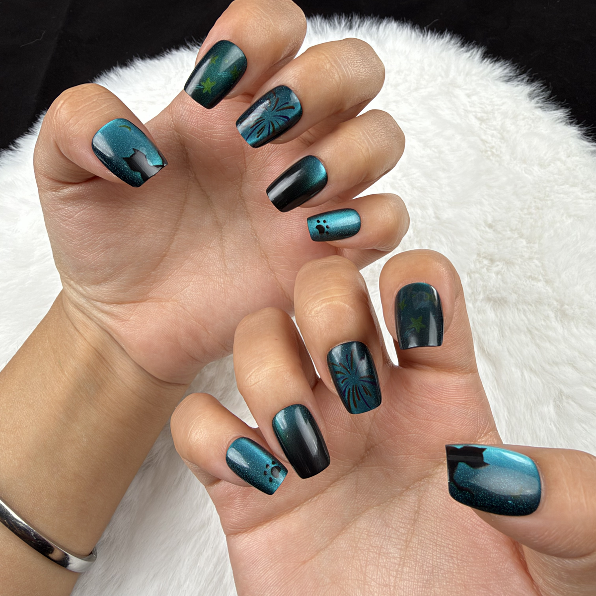 Hands wearing Ocean Afterglow teal and black cat eye square press-on nails