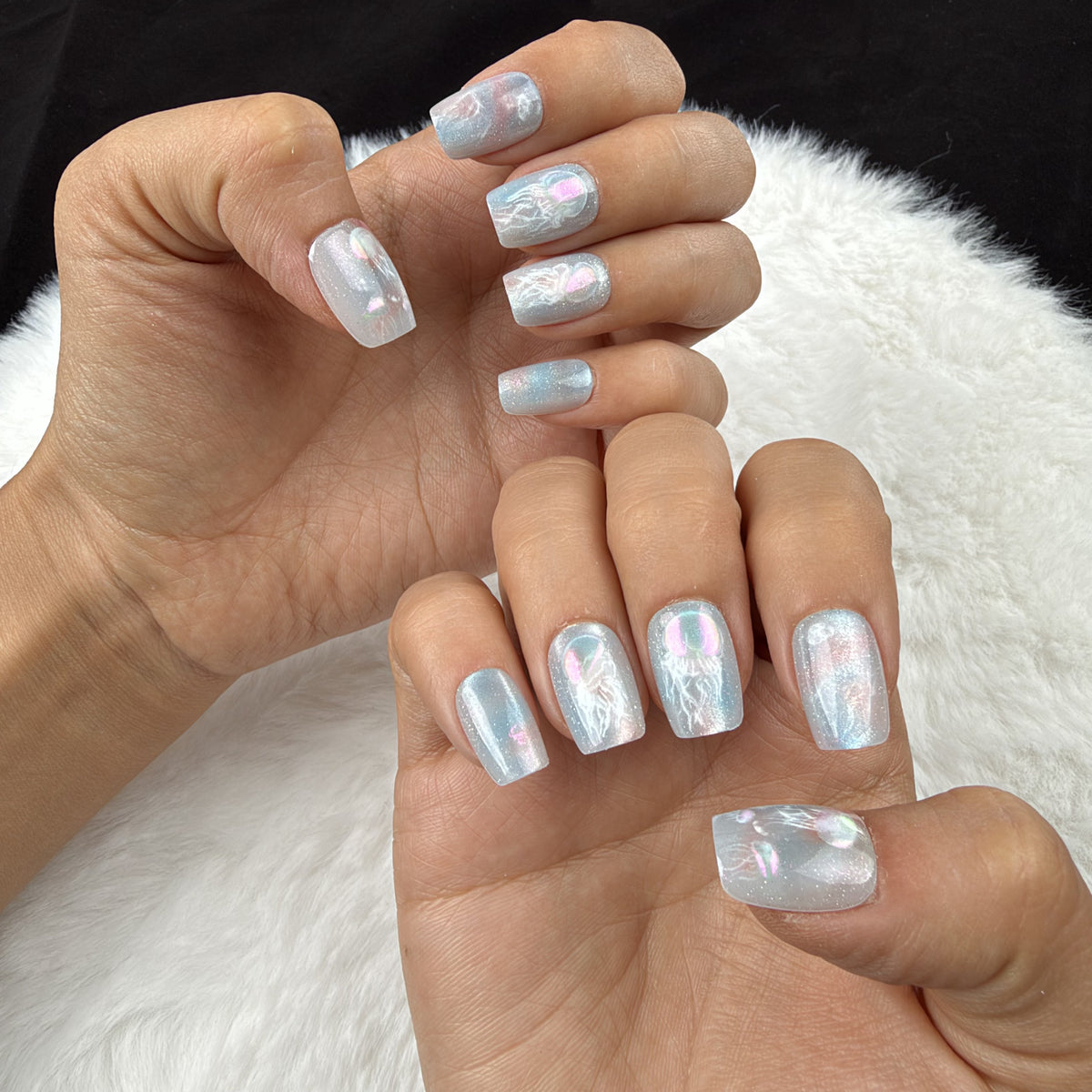 Hands wearing Jellyfish Drift blue iridescent jellyfish square press-on nails