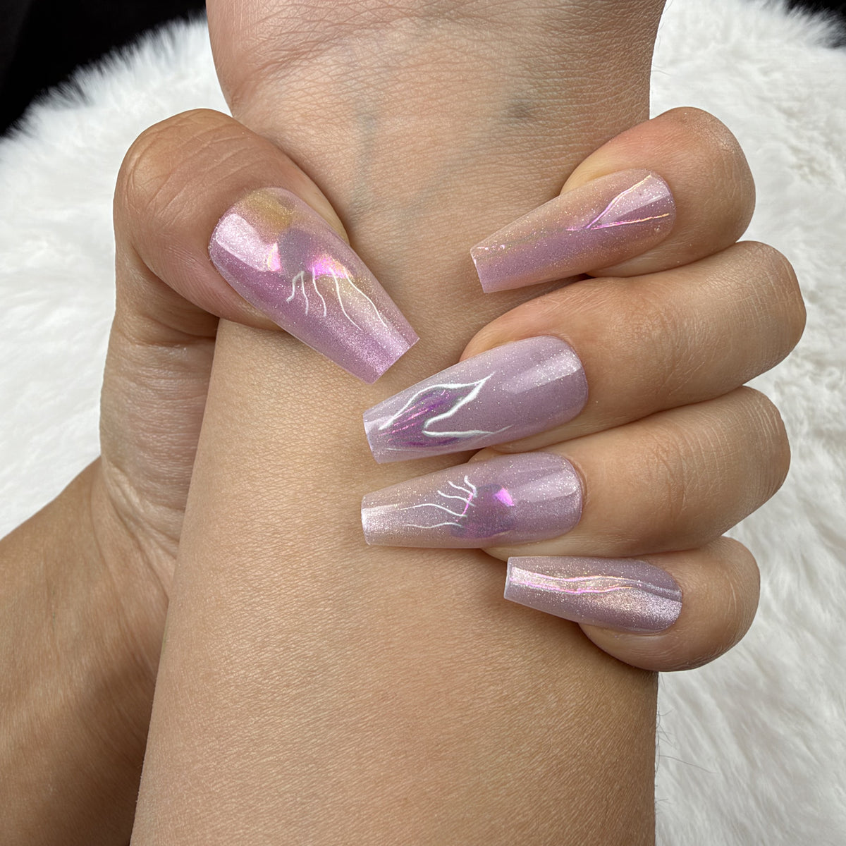 Close-up of hands wearing Iris Lightning lavender iridescent abstract coffin press-on nails