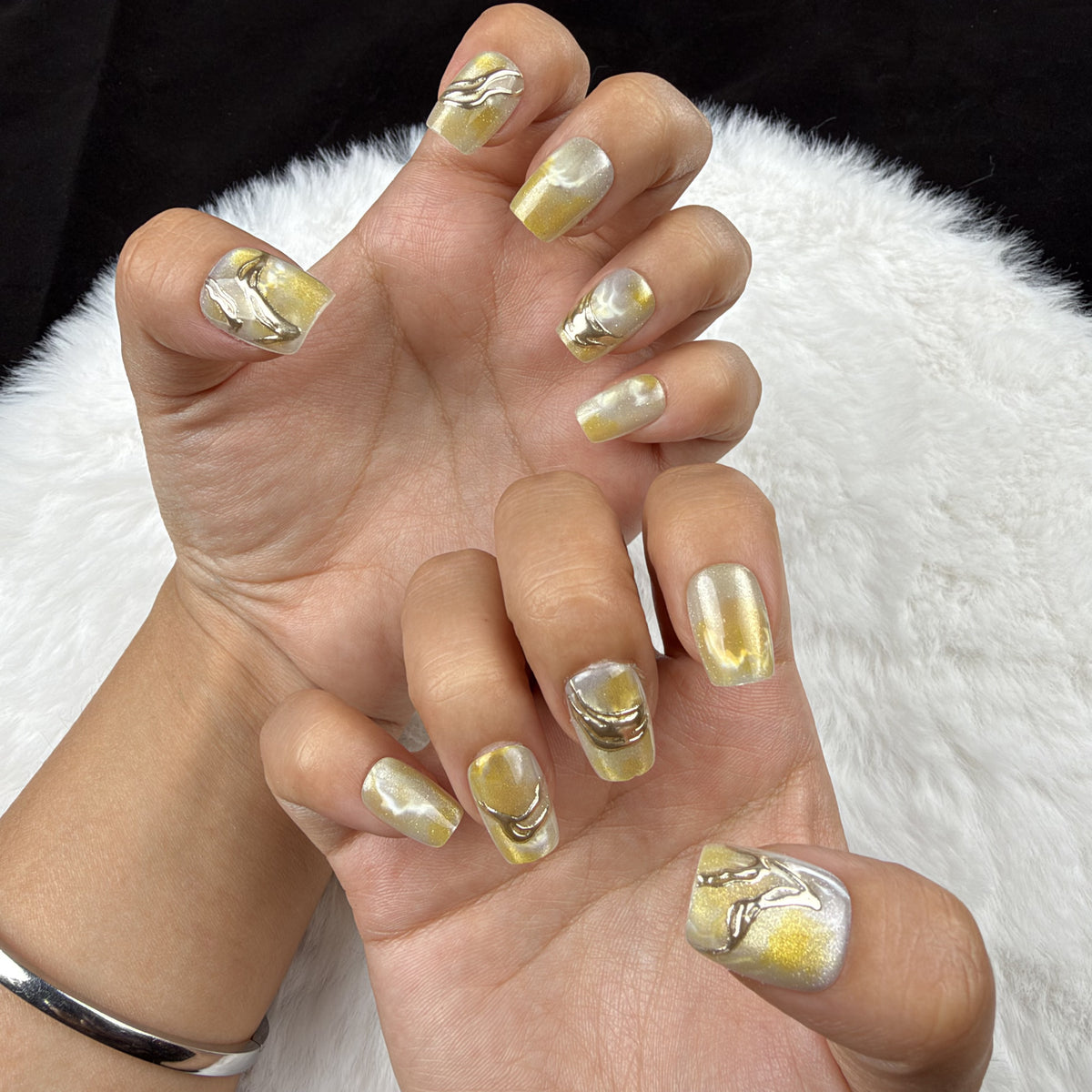Hands wearing Citrine Marble yellow marble square press-on nails with metallic accents