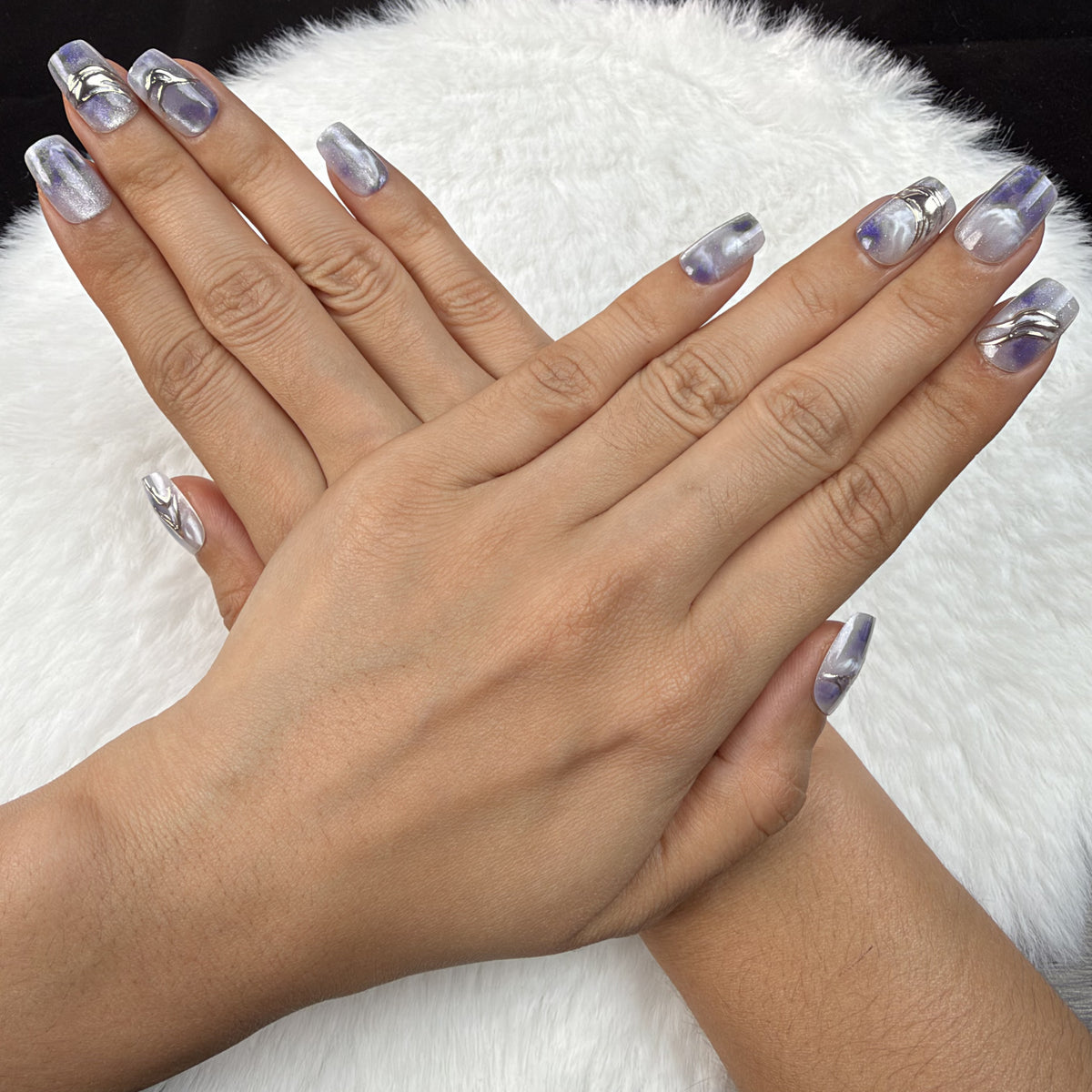Detail shot of Violet Marble blue-violet marble square press-on nails on hand