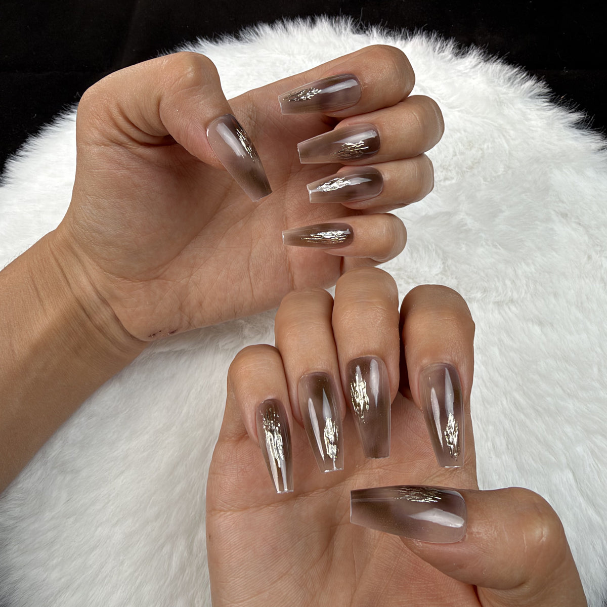 Hands wearing Mocha Foil brown chrome coffin press-on nails with metallic foil accents