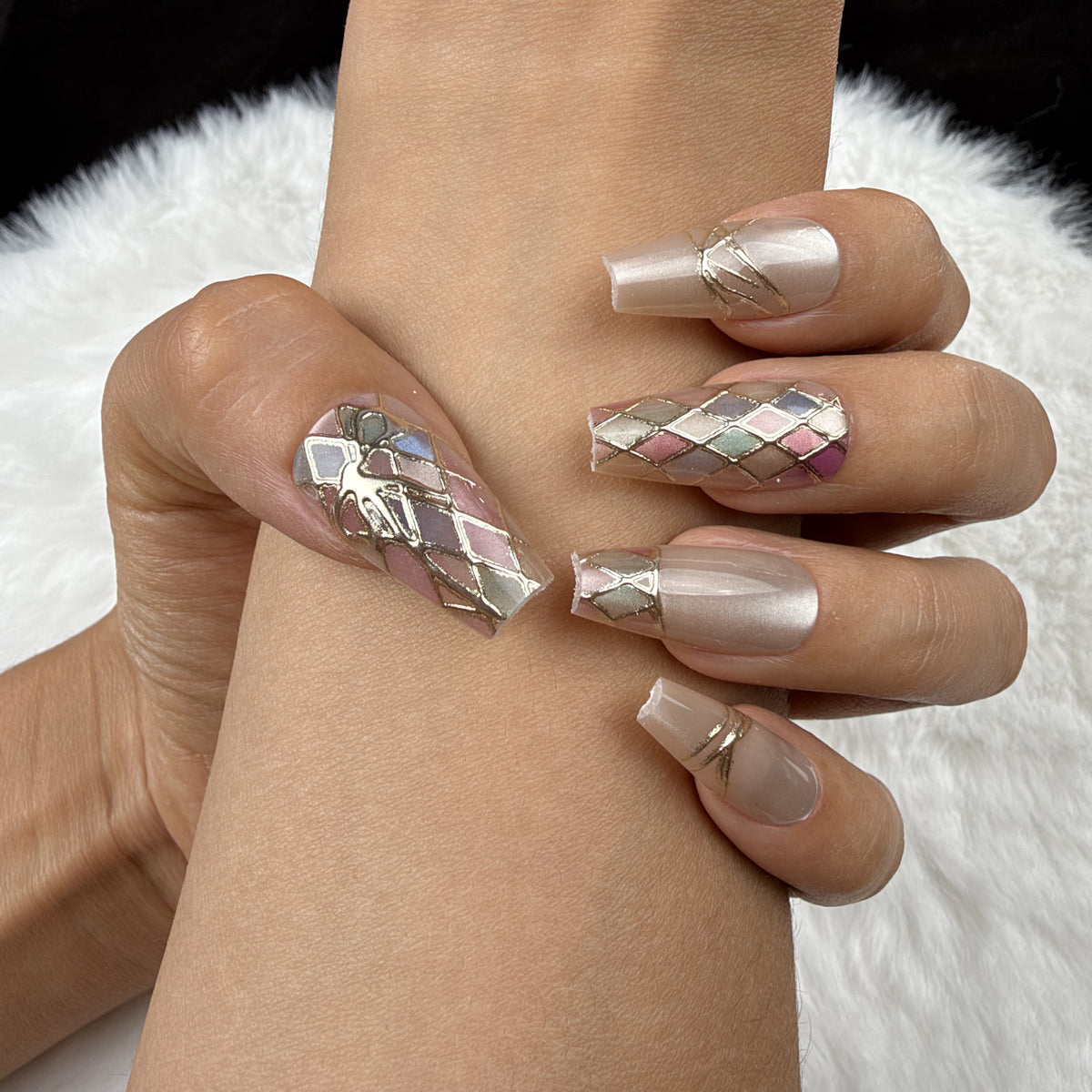 Close-up of hands wearing Pastel Mosaic pastel harlequin and bow coffin press-on nails