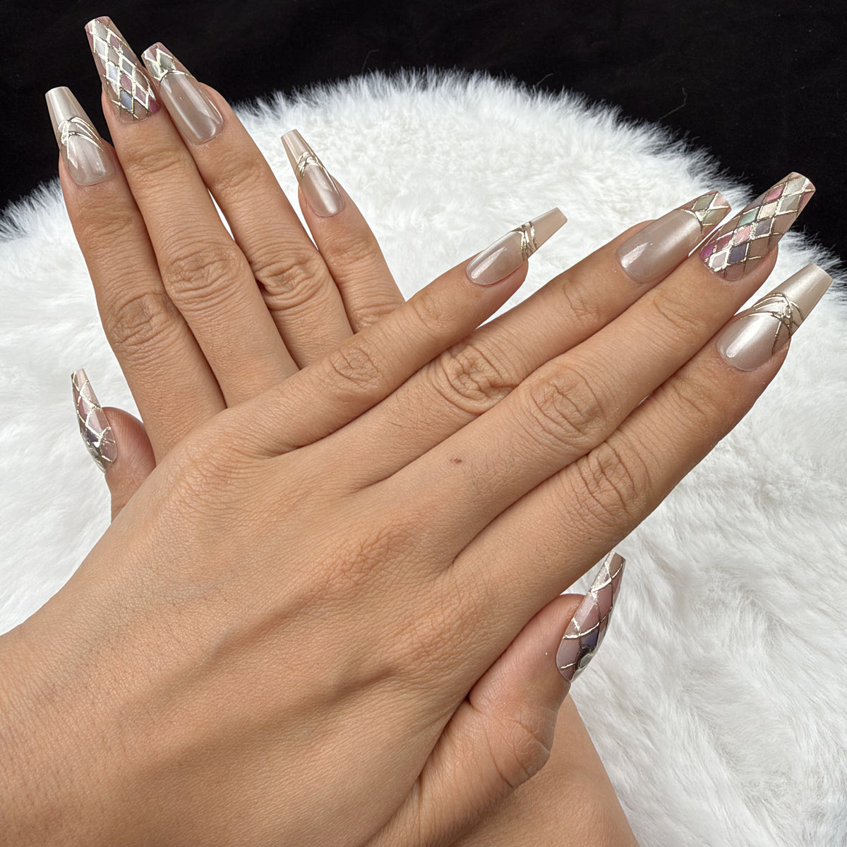 Detail shot of Pastel Mosaic pastel harlequin and bow coffin press-on nails on hand