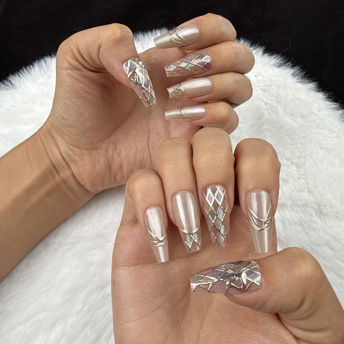 Hands wearing Pastel Mosaic pastel harlequin and bow coffin press-on nails
