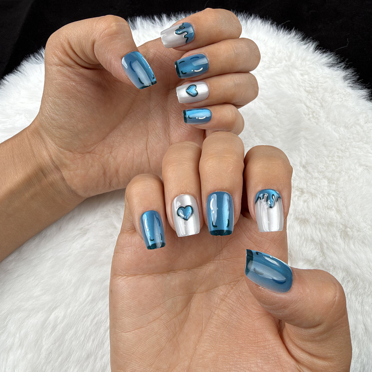 Hands wearing Blue Heart Drip blue chrome and pearl white heart square press-on nails