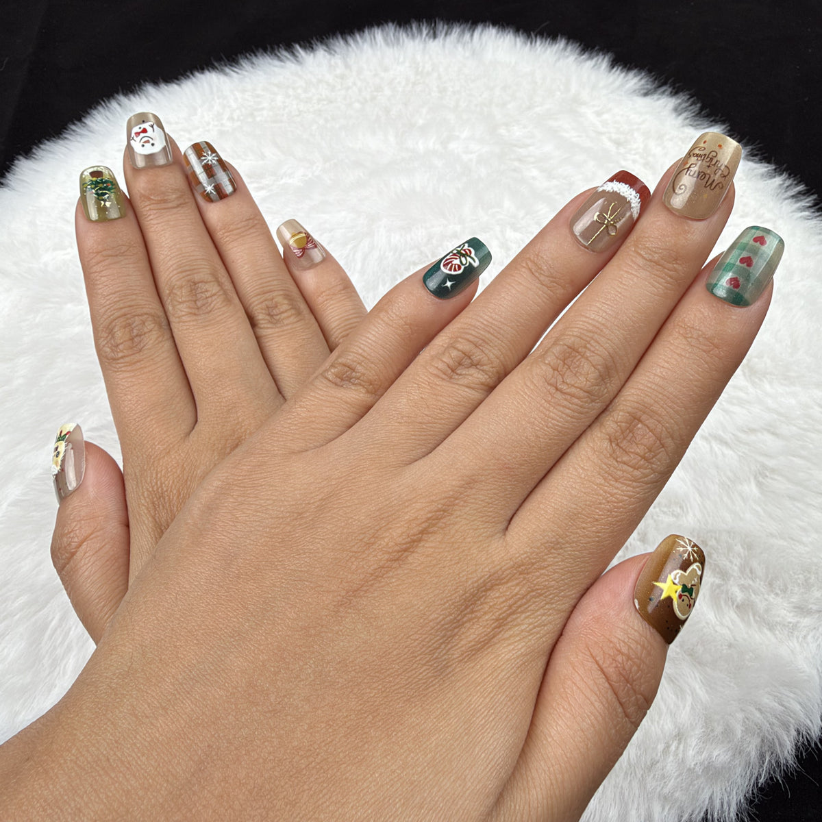 Detail shot of Holiday Patchwork plaid and festive Christmas square press-on nails on hand