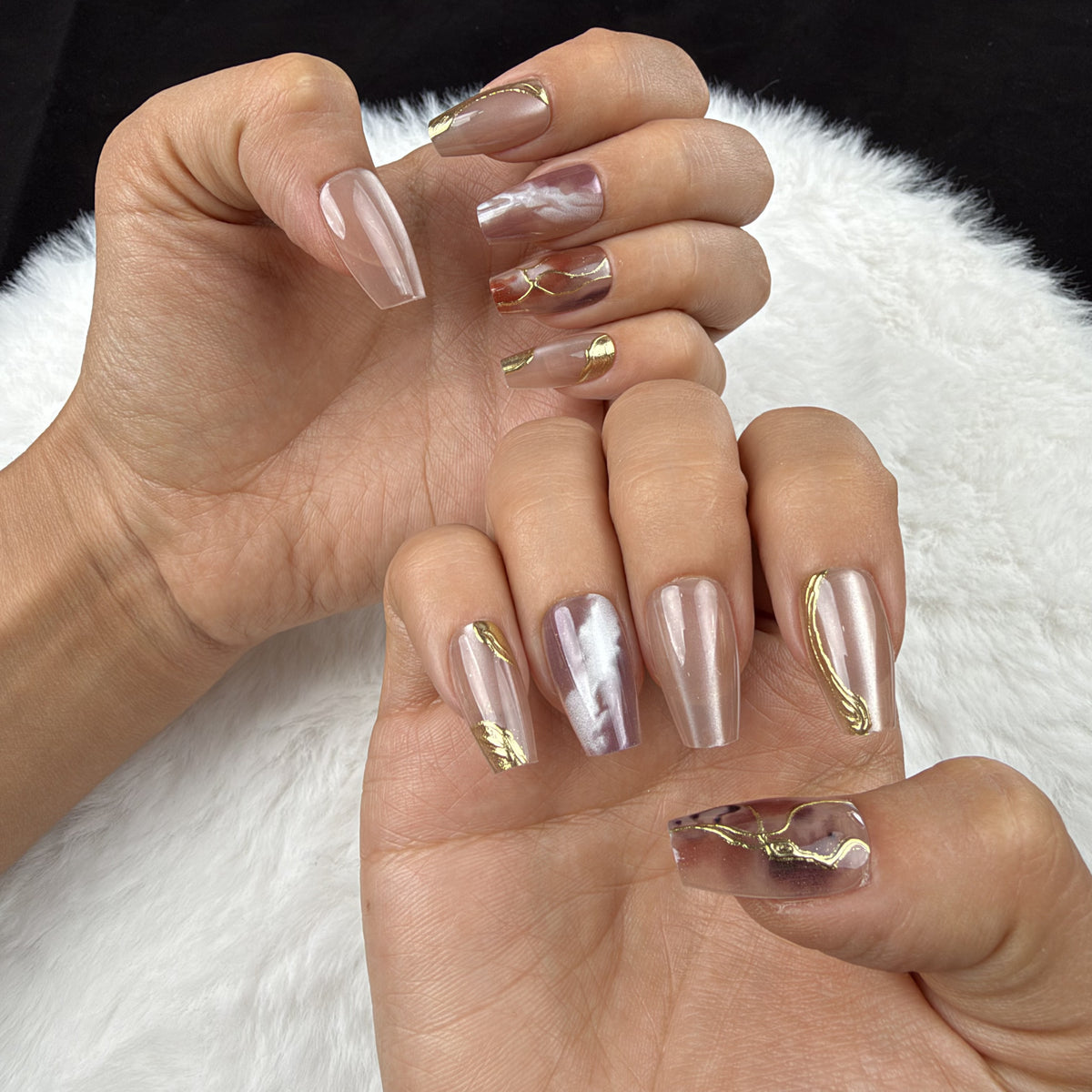 Hands wearing Amber Vein rose marble and gold-tone coffin press-on nails