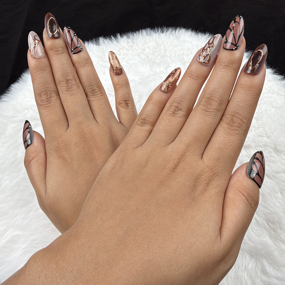 Detail shot of Copper Wings brown and copper butterfly wing almond press-on nails on hand