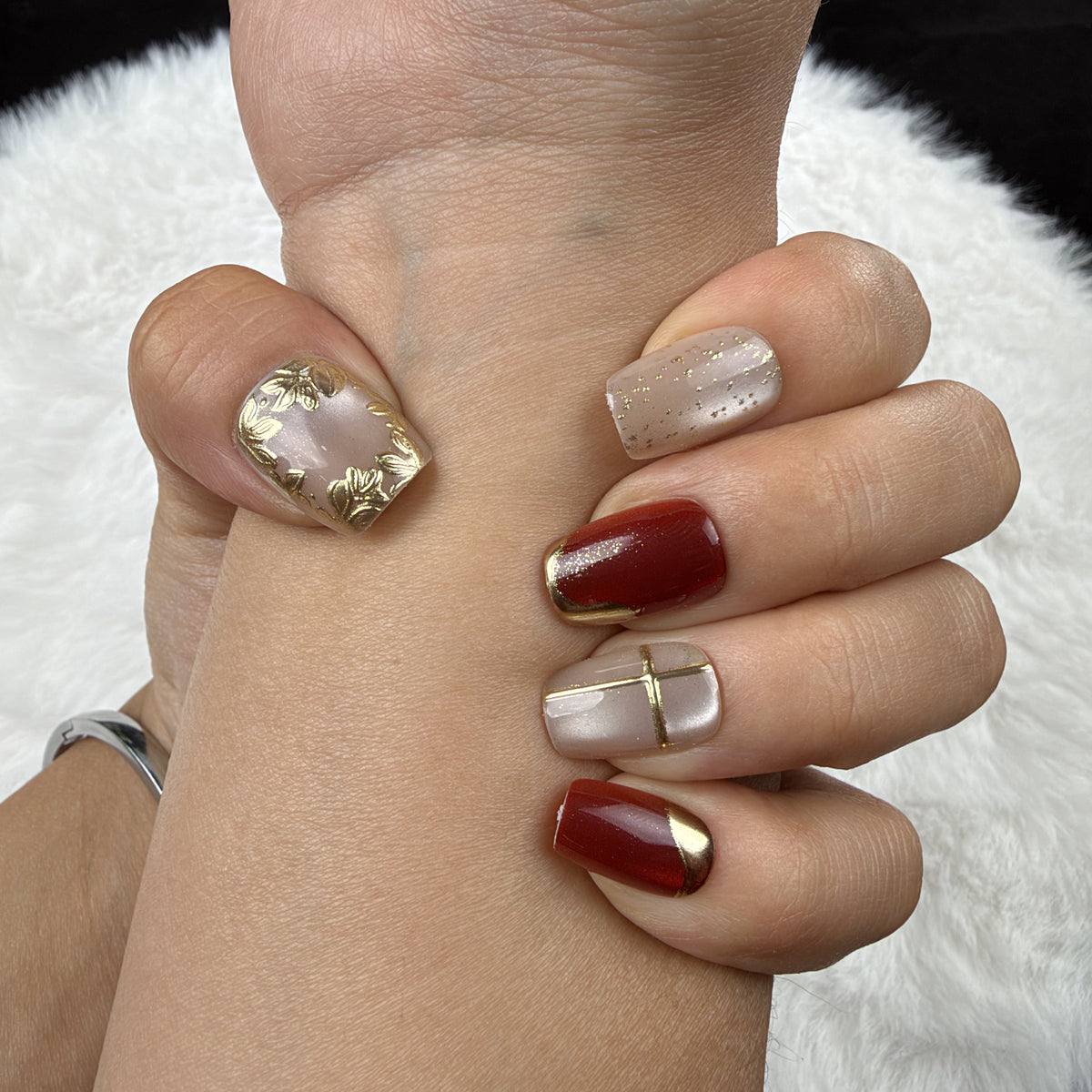 Close-up of hands wearing Crimson Frame red and gold-tone square press-on nails
