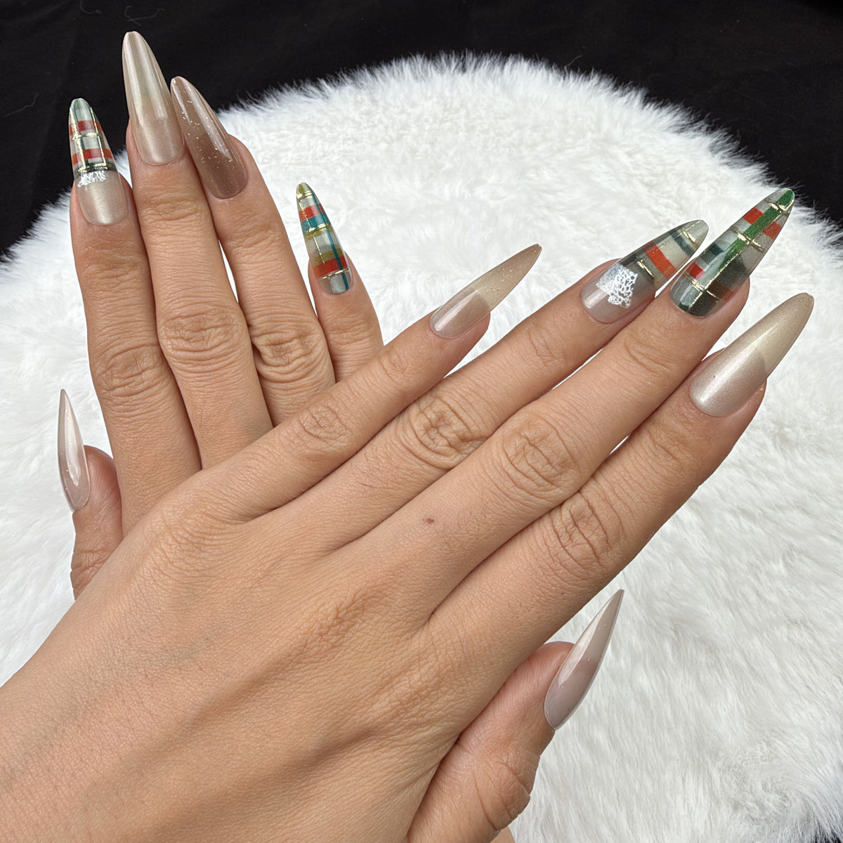 Detail shot of Cozy Plaid champagne and green plaid Christmas almond press-on nails on hand