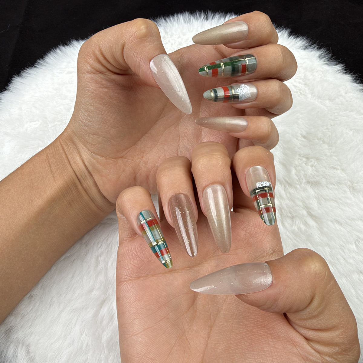 Hands wearing Cozy Plaid champagne and green plaid Christmas almond press-on nails