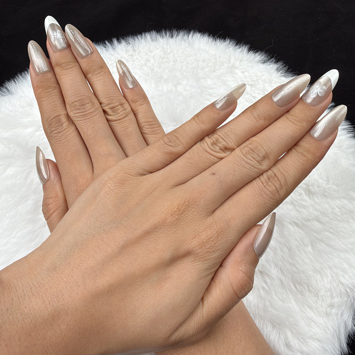 Detail shot of Pearl Petal nude pearl French tip almond press-on nails on hand