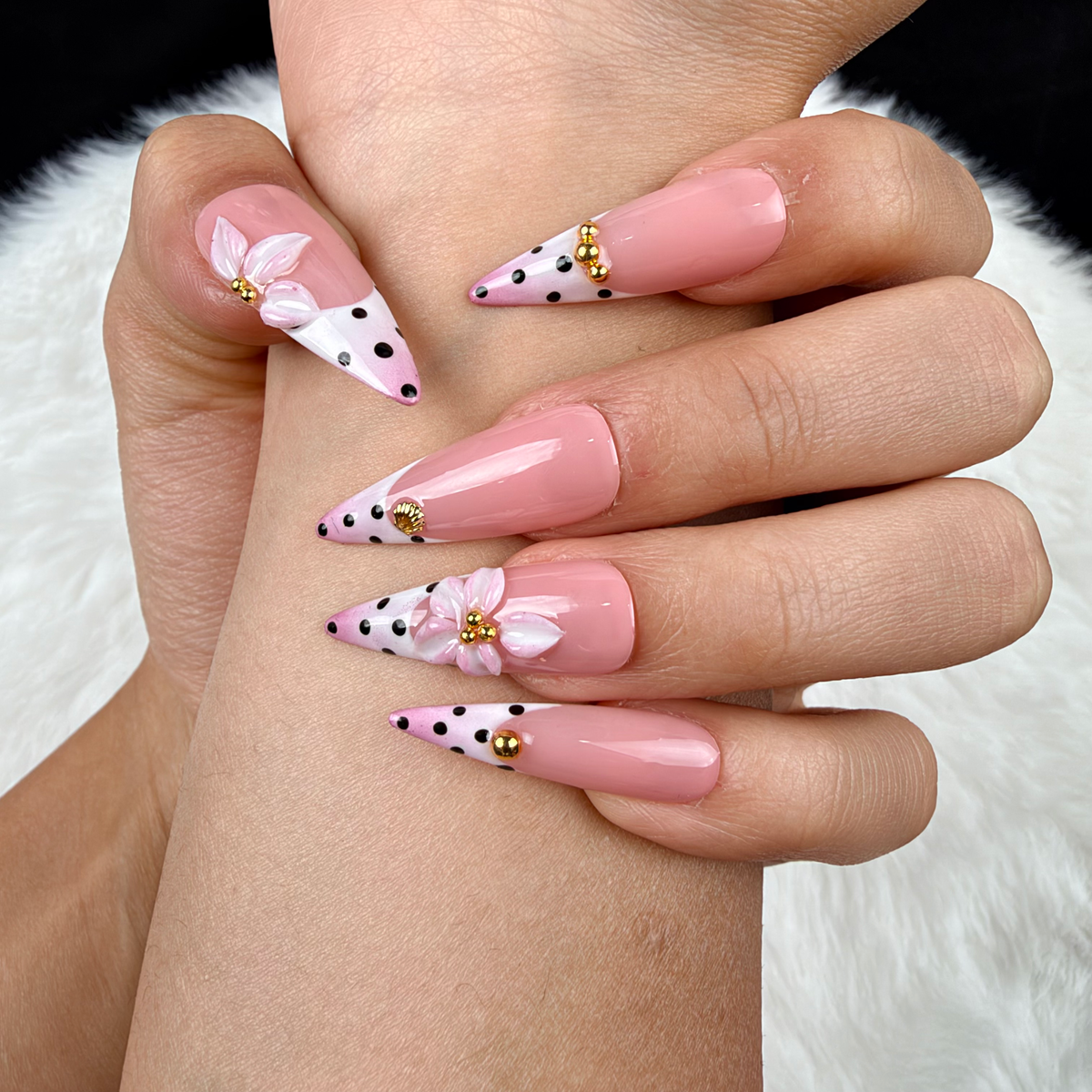 Detail shot of Blush Polka pink polka dot French tip floral almond press-on nails on hand