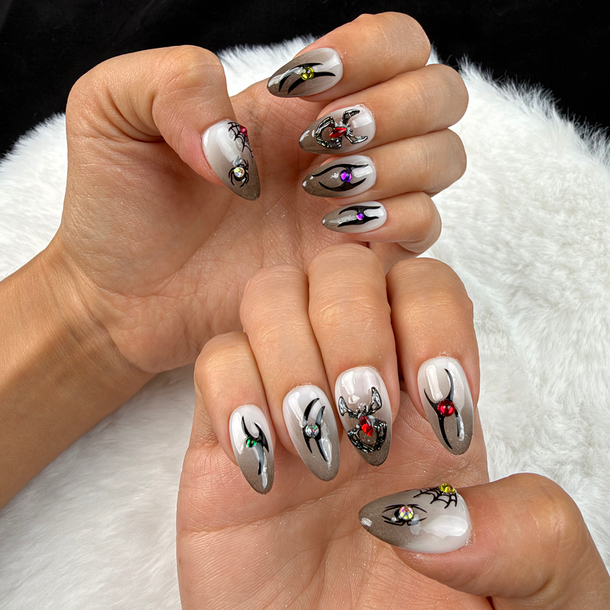 Hands wearing Midnight Creepers grey spider Halloween almond press-on nails