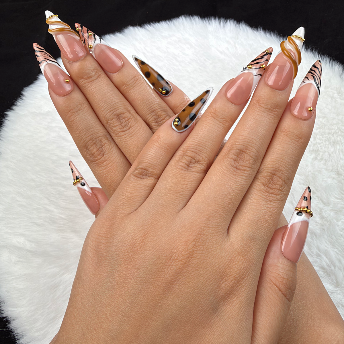 Detail shot of Wild French animal print French tip almond press-on nails with gold accents on hand