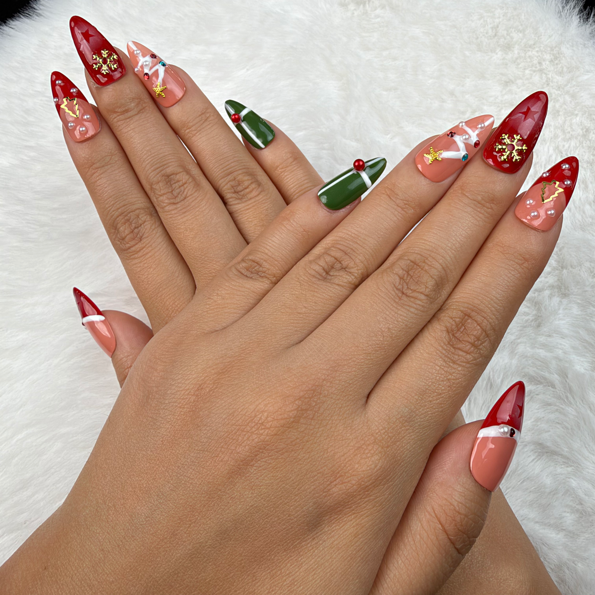 Detail shot of Christmas Keepsakes red, green and nude French tip Christmas almond press-on nails on hand