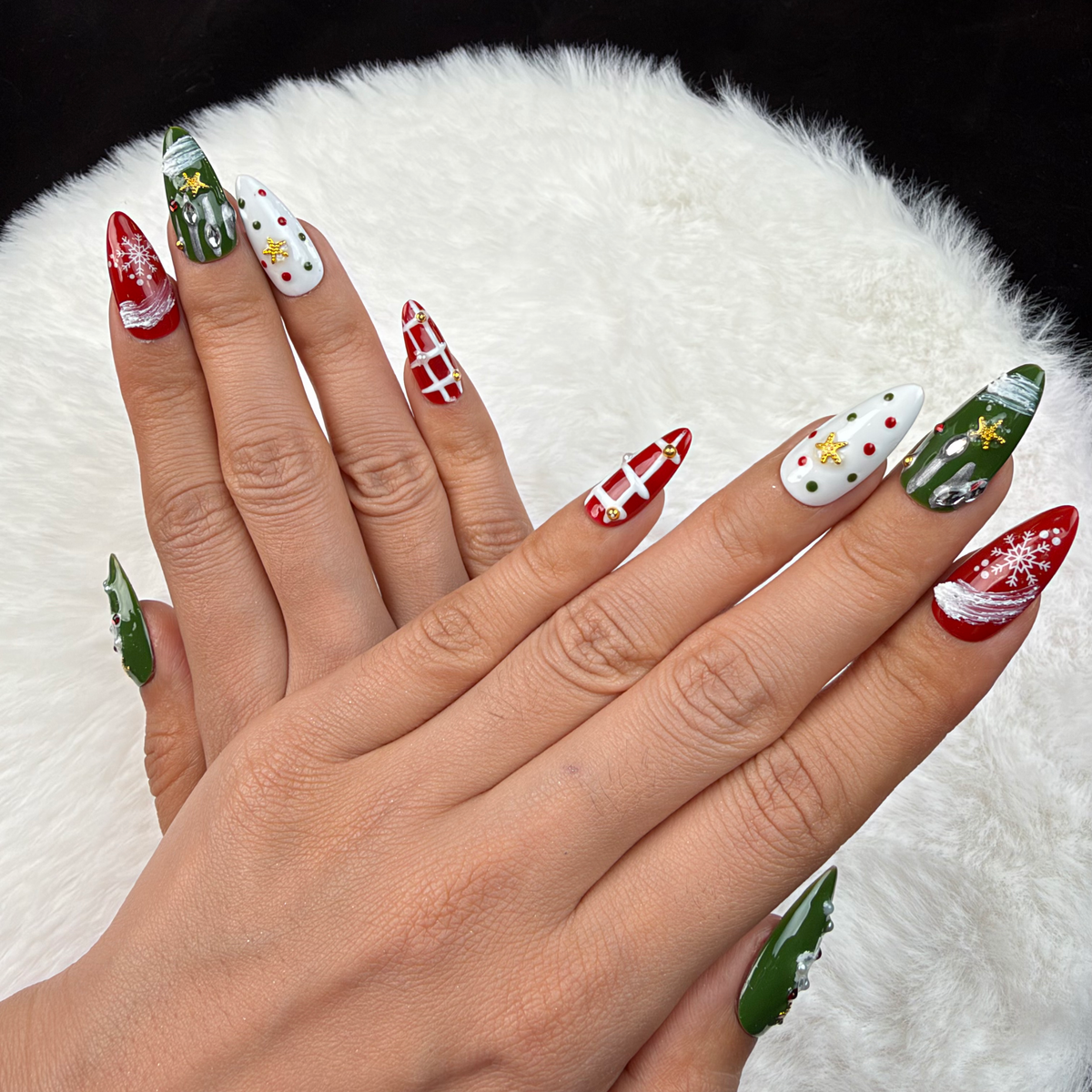 Detail shot of Winter Parcel red and green ribbon and plaid Christmas almond press-on nails on hand