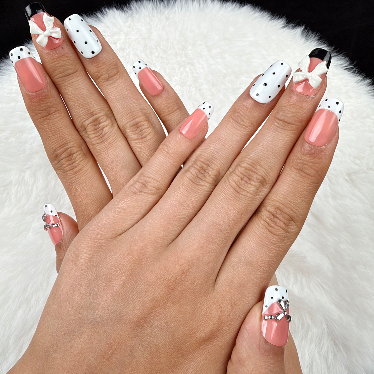 Hands wearing Polka Bow black and white polka dot bow square press-on nails