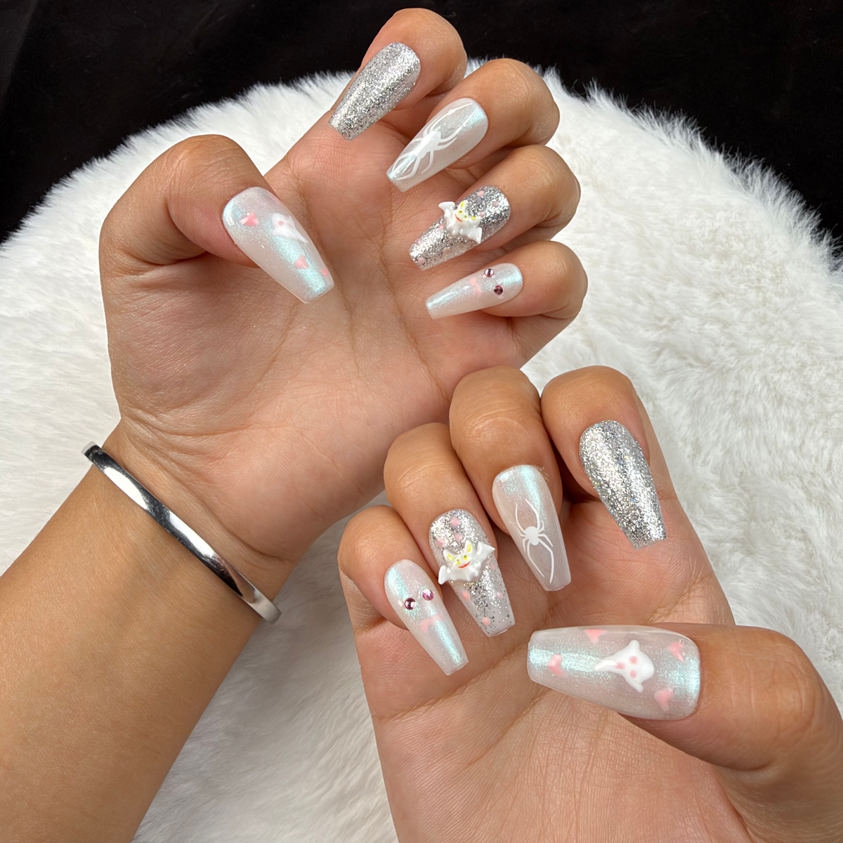 Hands wearing Ghostly Frost white and silver glitter Halloween square press-on nails