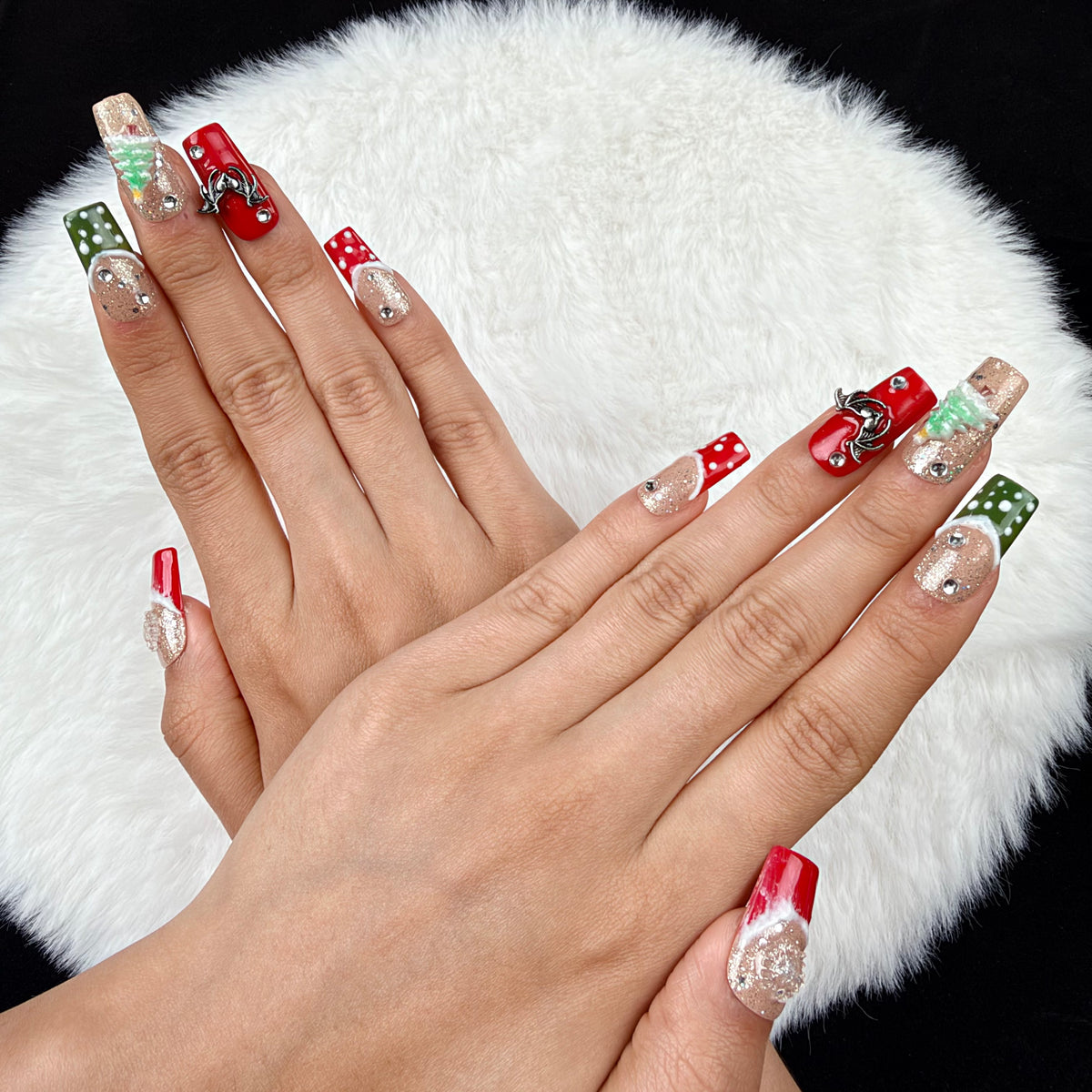 Close-up of hands wearing Gingerbread Party red, green and glitter Christmas square press-on nails with gingerbread and tree designs