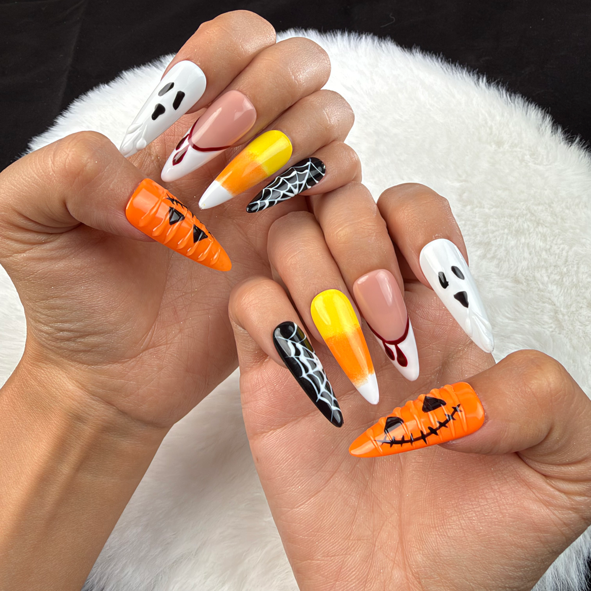 Hands wearing Haunted Parade ghost, pumpkin and spiderweb Halloween stiletto press-on nails