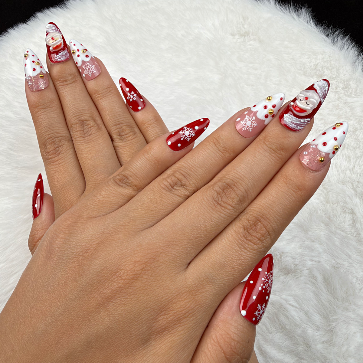 Detail shot of Santa Snow red and white Santa Christmas almond press-on nails on hand