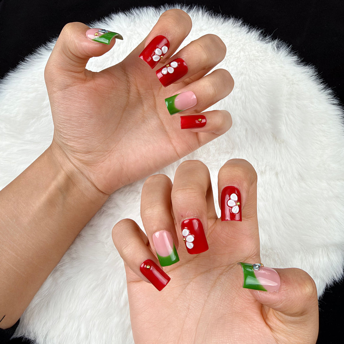 Detail shot of Garden Contrast red, green and white floral square press-on nails on hand