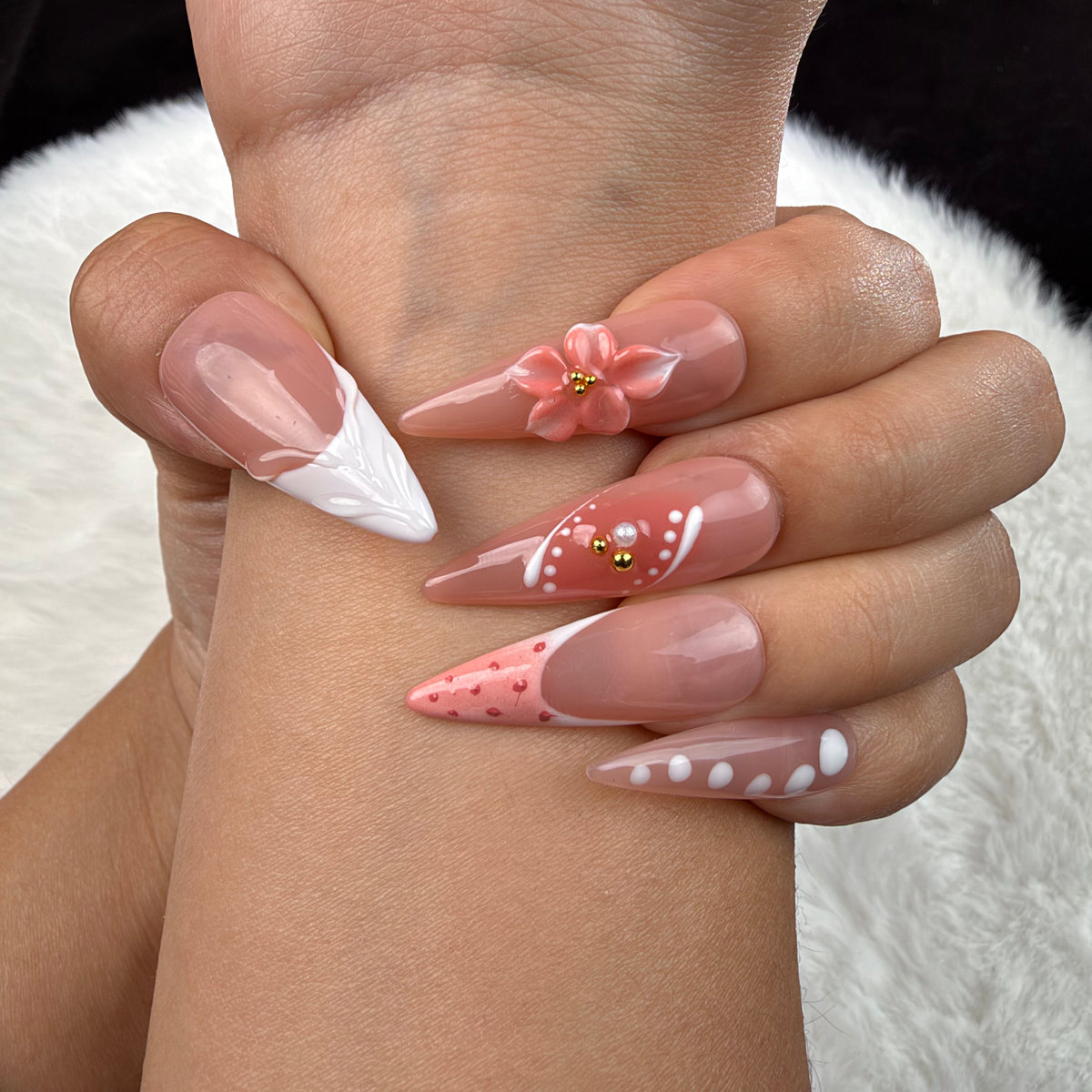 Detail shot of Peach Bloom nude pink and white French floral almond press-on nails on hand