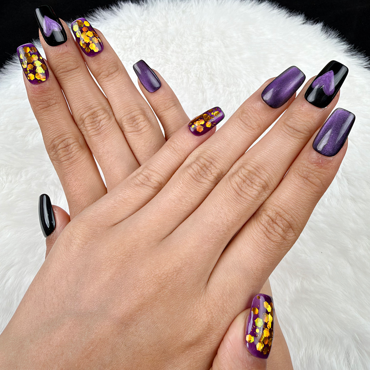 Hands wearing Purple Hearts purple cat eye and gold glitter heart square press-on nails