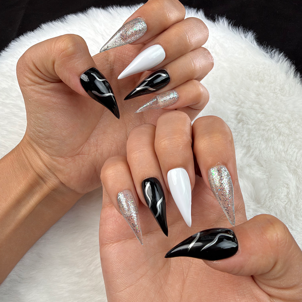Hands wearing Silver Current black, white and silver glitter stiletto press-on nails