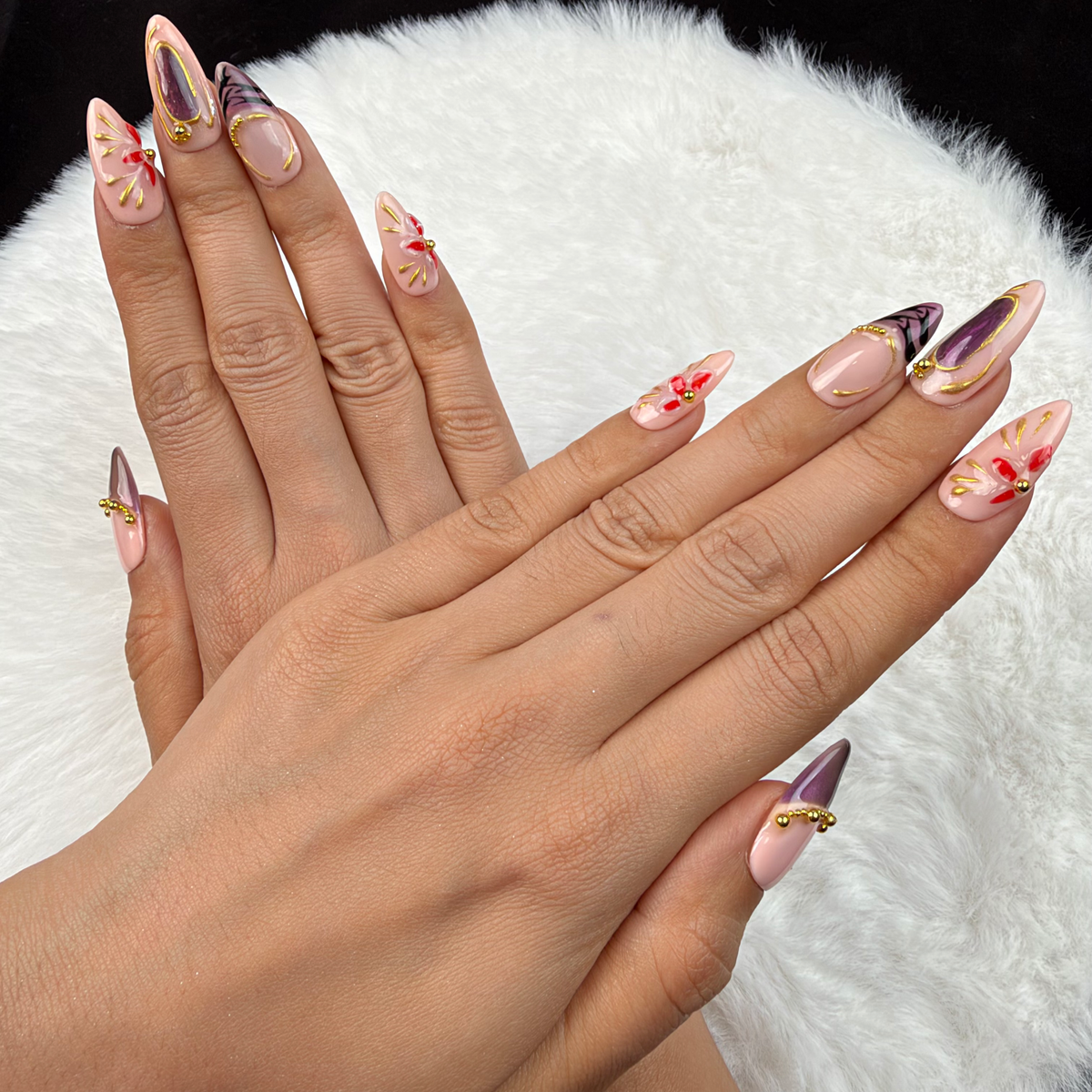 Detail shot of Amethyst Bloom purple and gold floral almond press-on nails on hand