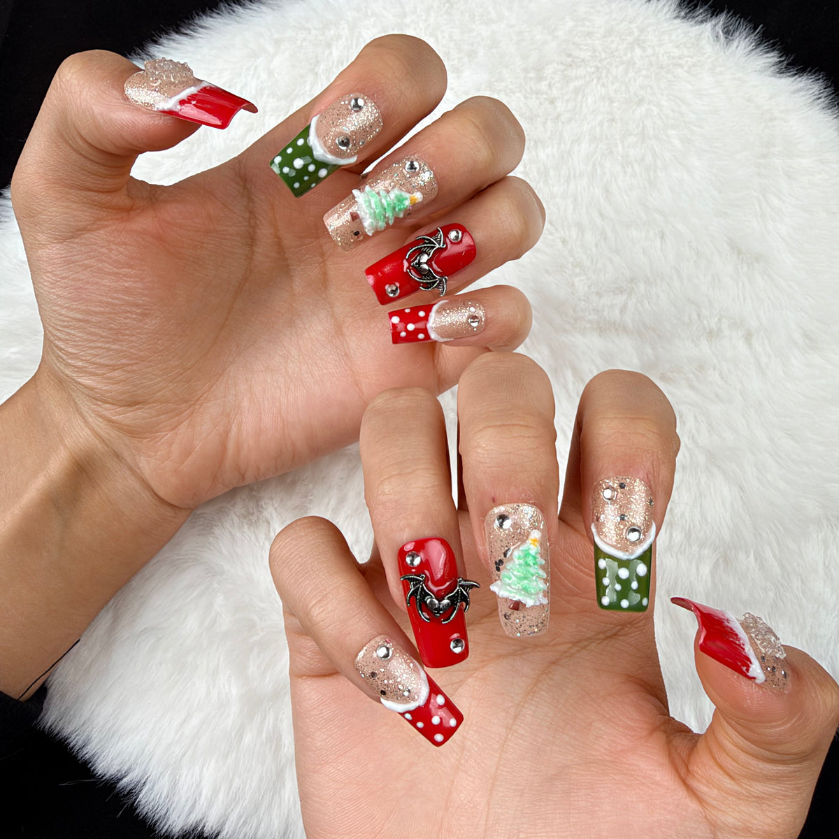 Detail shot of Gingerbread Party red, green and glitter Christmas square press-on nails with gingerbread and tree designs on hand