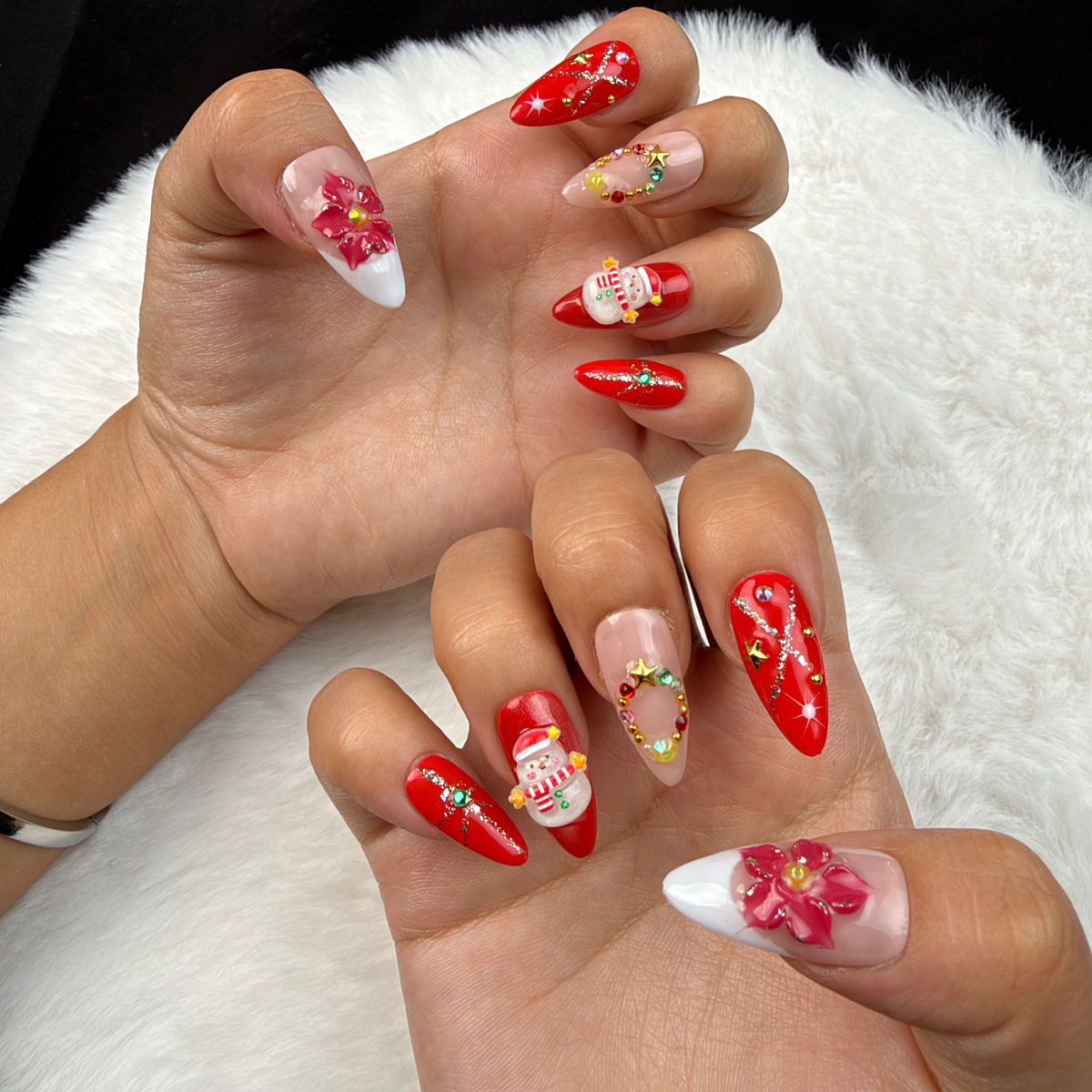 Hands wearing Holly Bloom red floral and snowman Christmas almond press-on nails