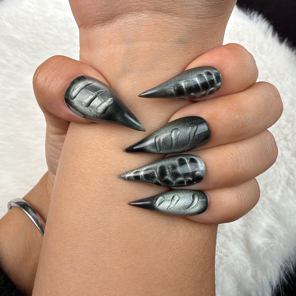 Close-up of hands wearing Chrome Shadow black and silver chrome stiletto press-on nails