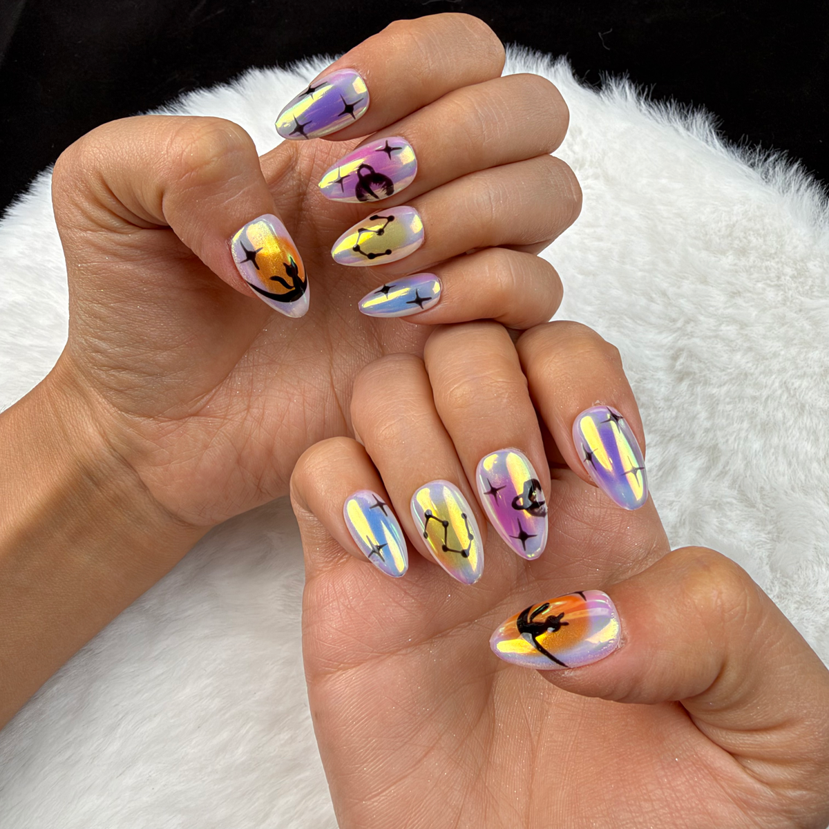 Hands wearing Aurora Signs iridescent celestial almond press-on nails