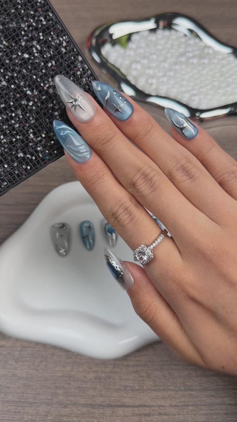 Step-by-step application of Blue Orbit icy blue cat eye celestial almond press-on nails with silver details