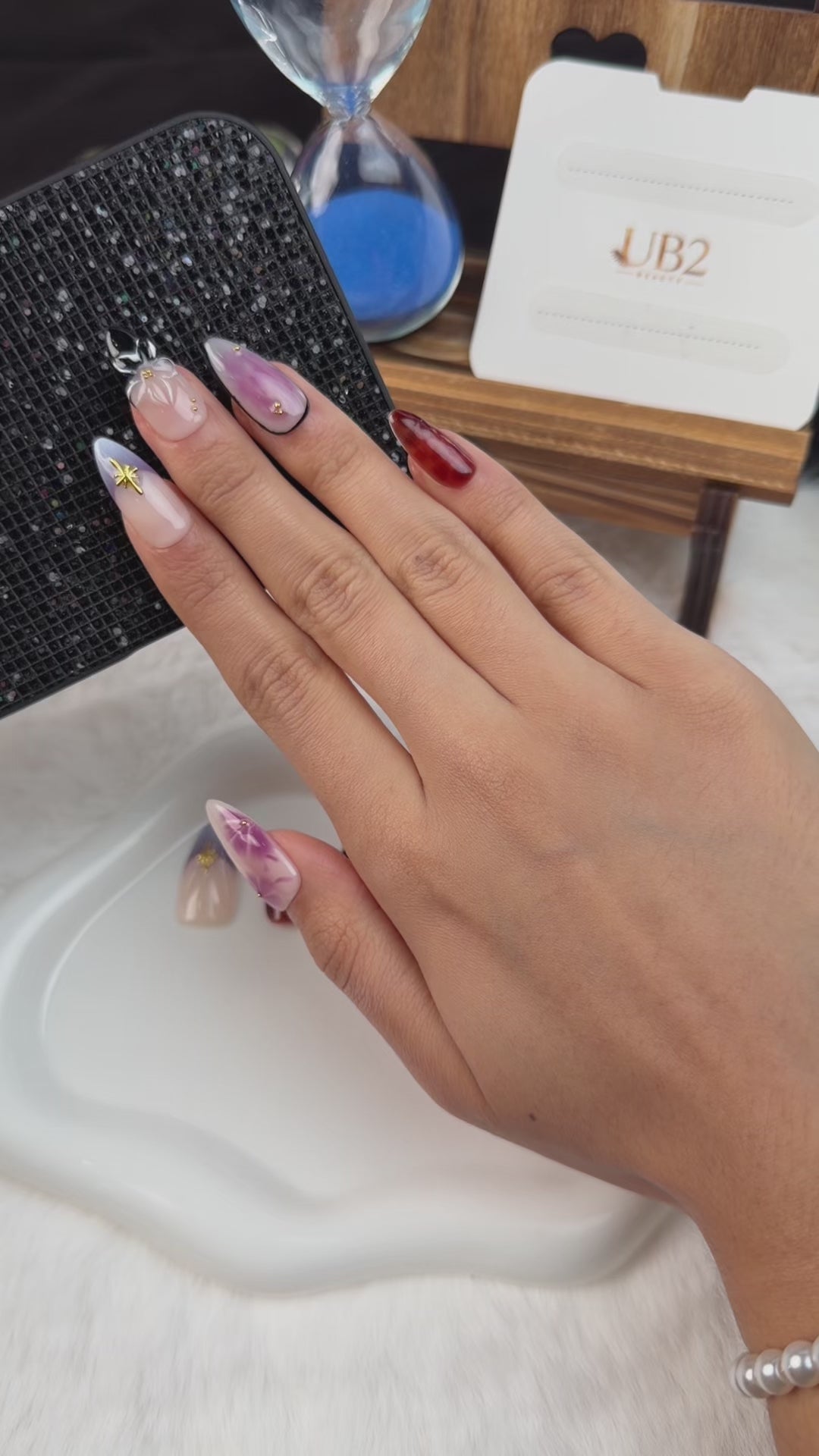Load video: Step-by-step application of Violet Tortoise lavender tortoiseshell floral bow medium almond press-on nails